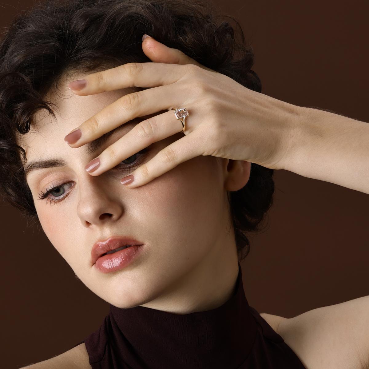 Brownish pink radiant cut lab grown diamond engagement ring worn on hand