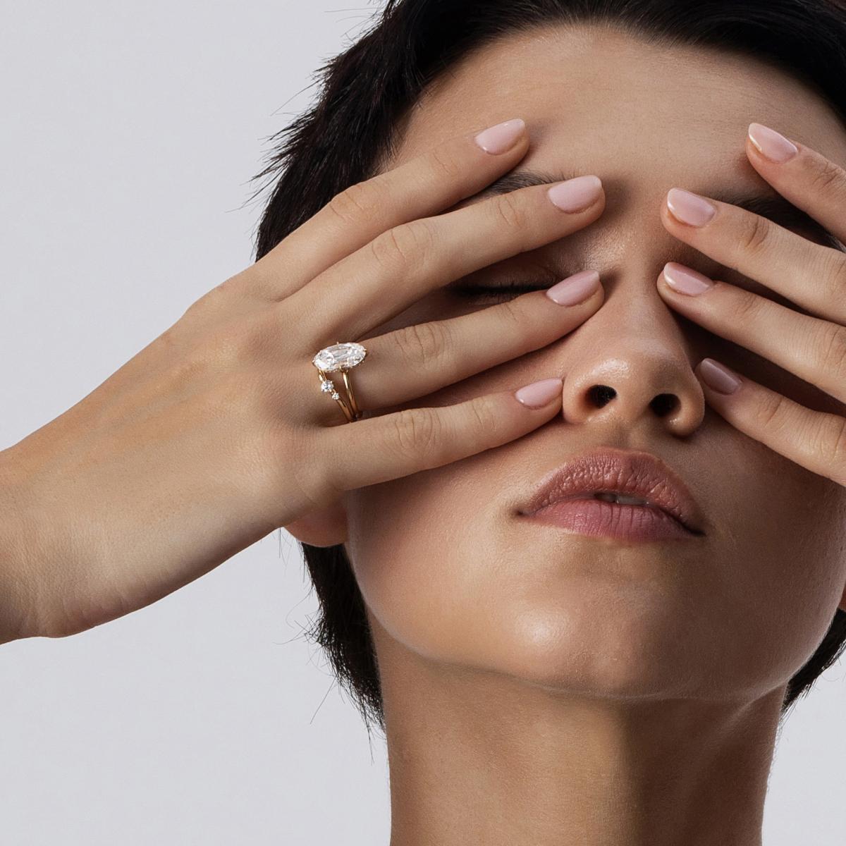 Close-up of model wearing Belle Moval diamond ring stacked with a contour band