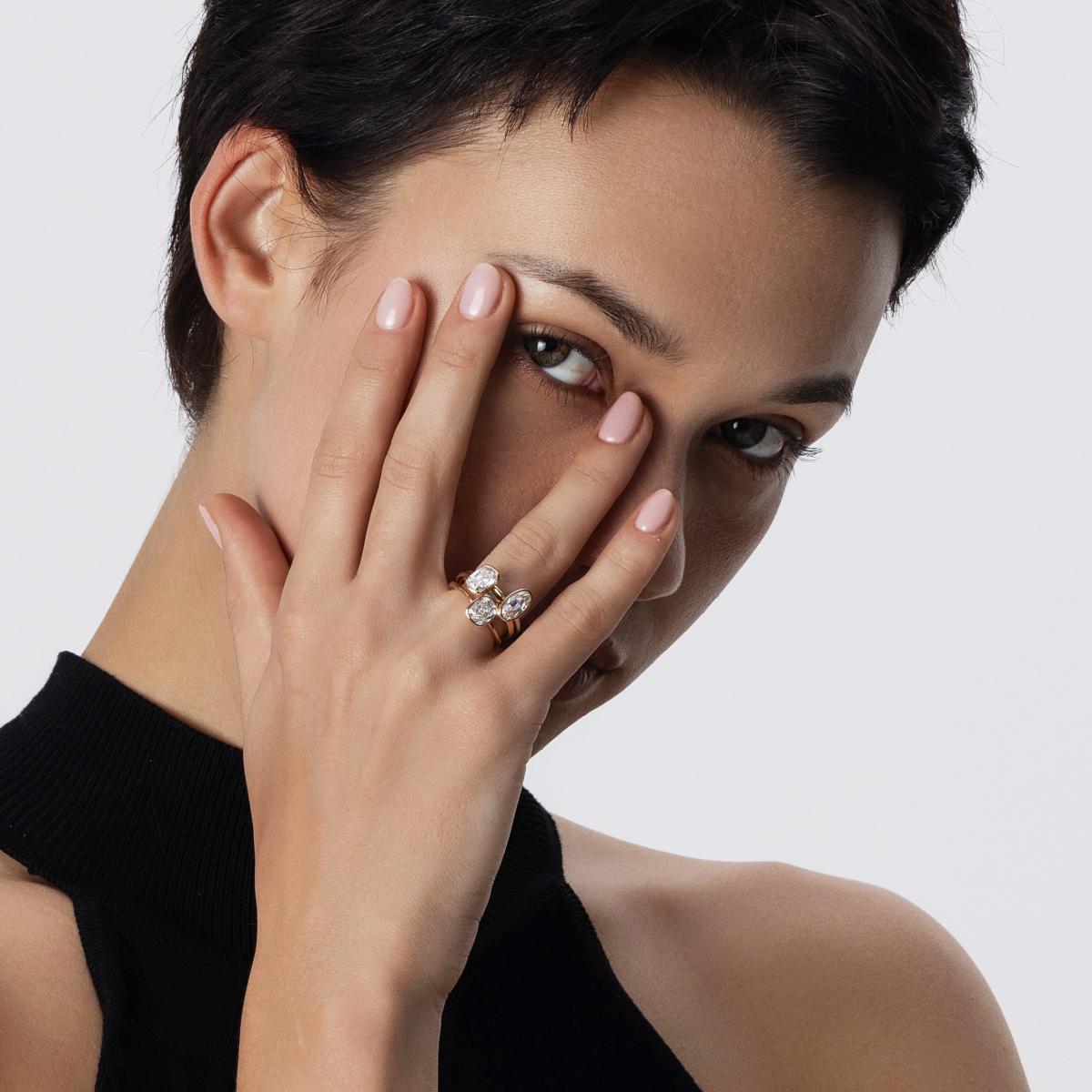 Front-facing view of model showcasing stackable look of 3 bezel-set diamond rings