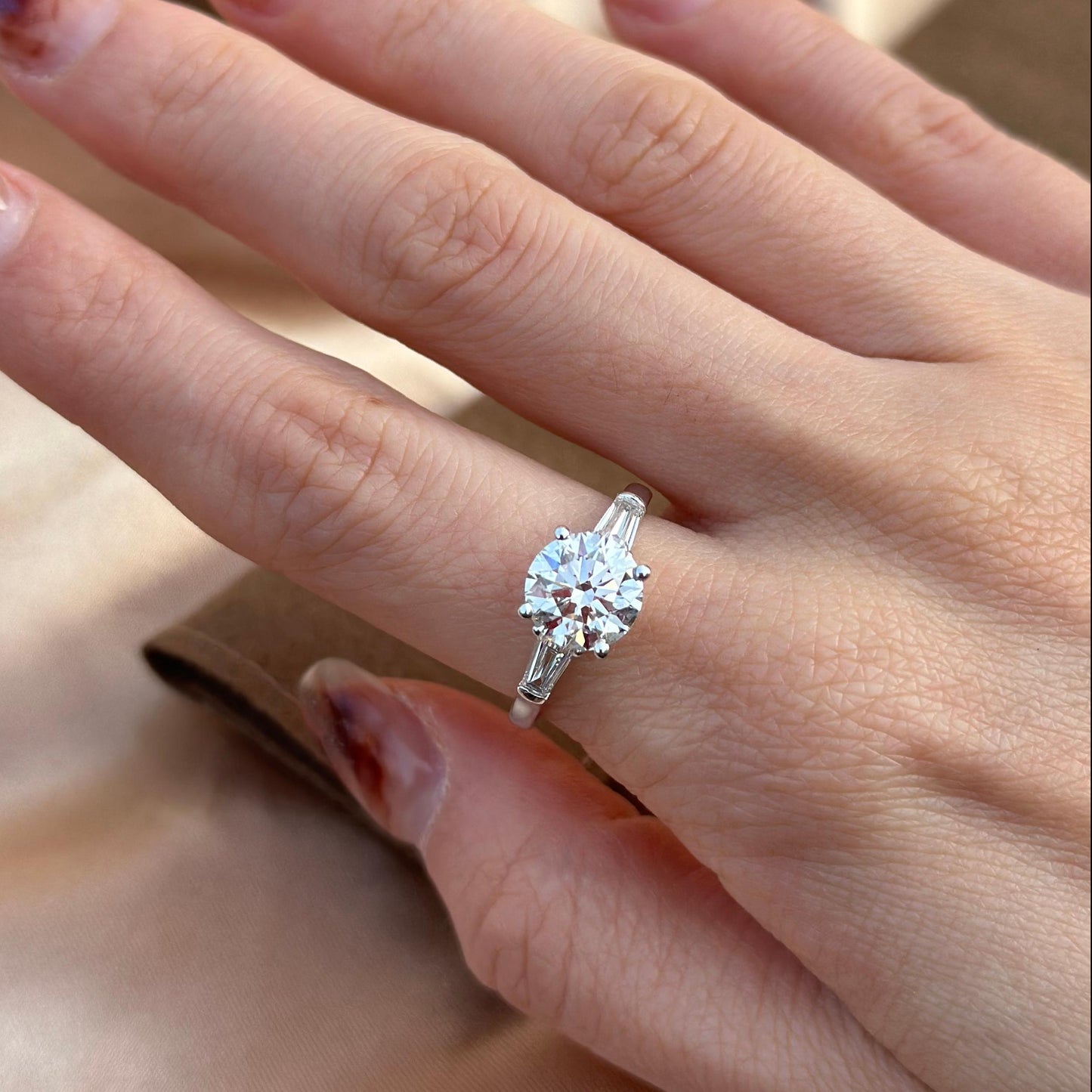 Hand-closeup Amber Three Stone Round Cut Lab Grown Diamond Engagement Ring