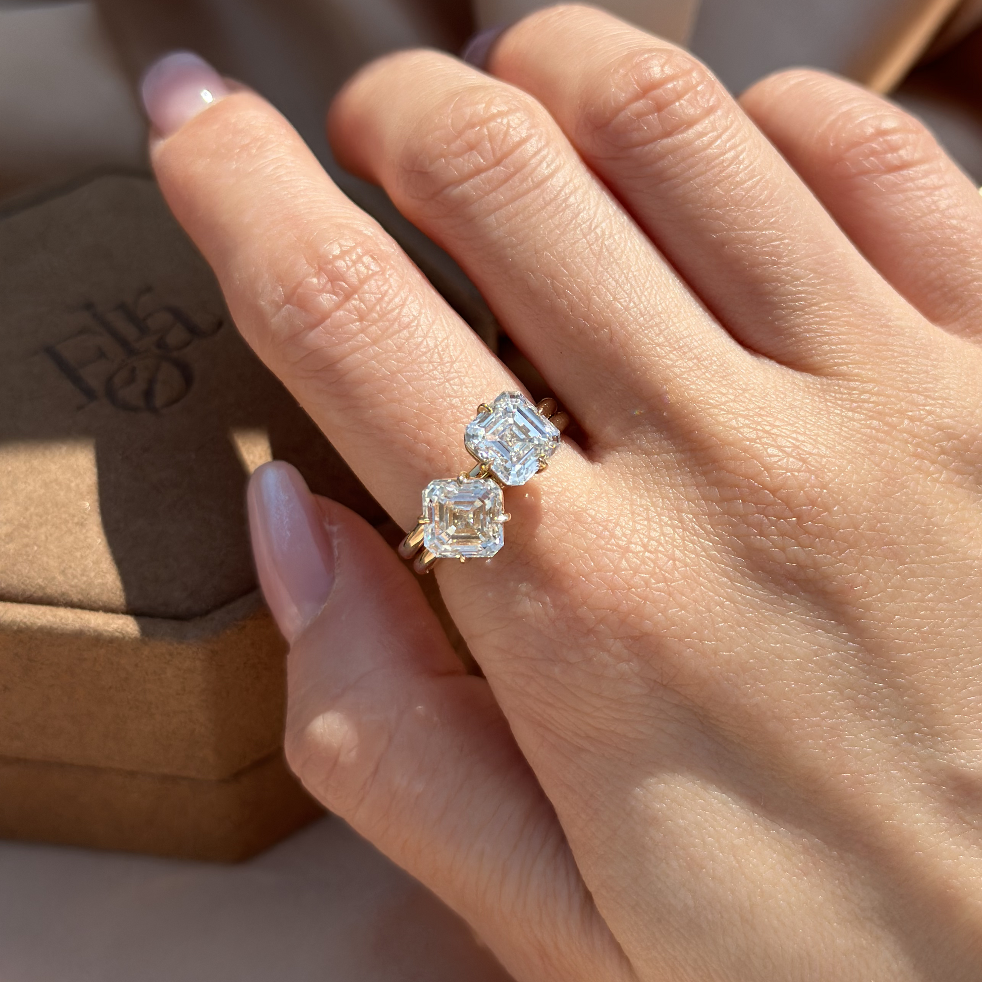 Model hand wearing 2 Asscher Cut diamond rings in minimalist style look