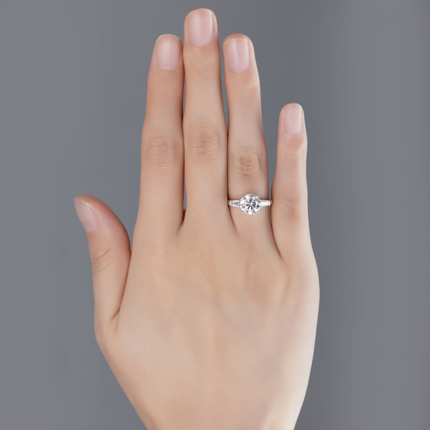 Model hand wearing Three-Stone Round Cut lab-grown diamond Ring in minimalist style
