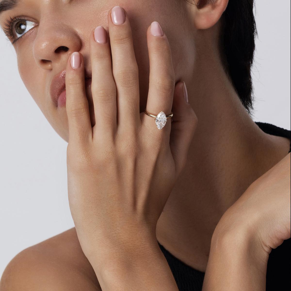 Model hand wearing a Solitaire Marquise Cut diamond engagement ring in 14K Gold
