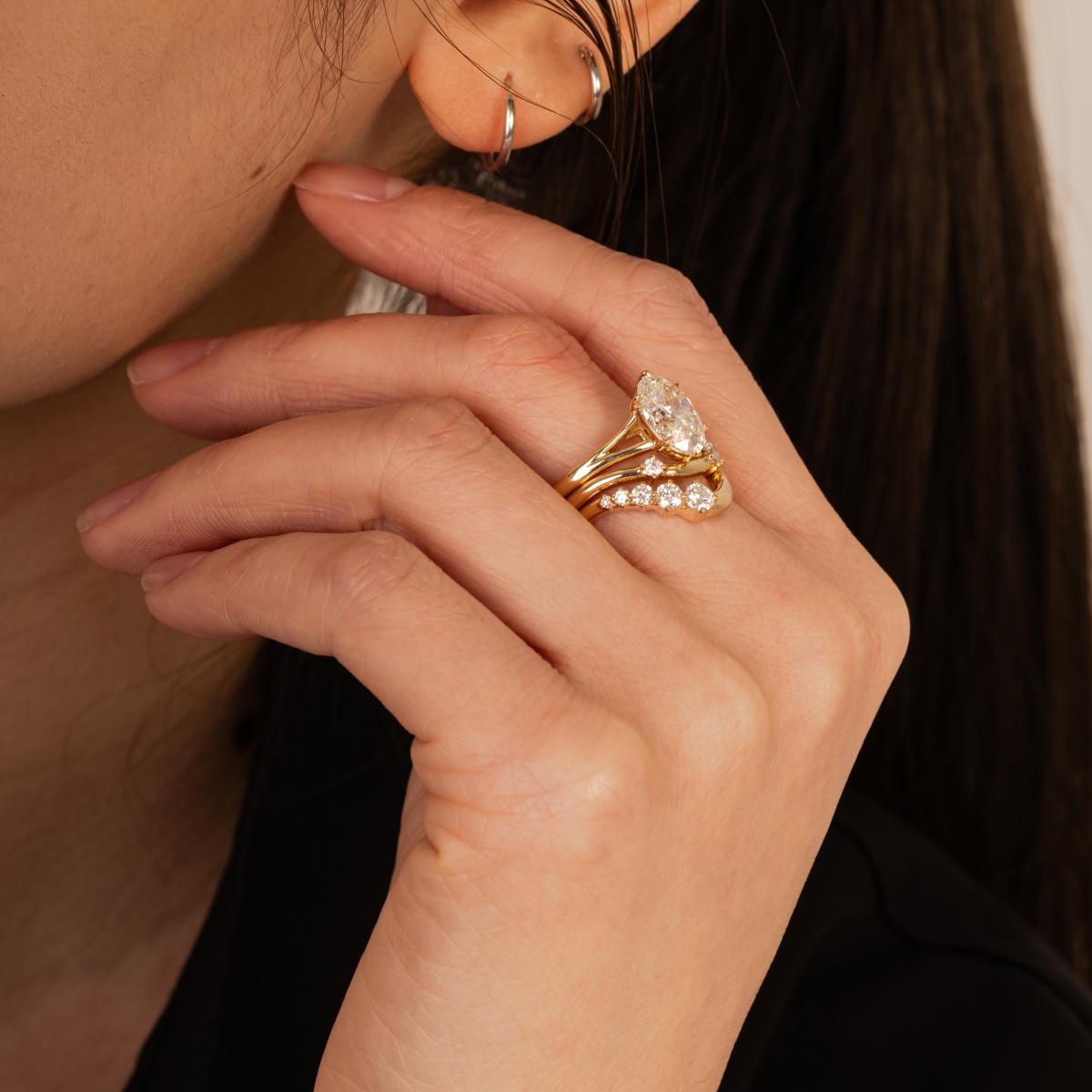Model hand wearing a layered stack of Edith Oval diamond ring in mixed gold tones