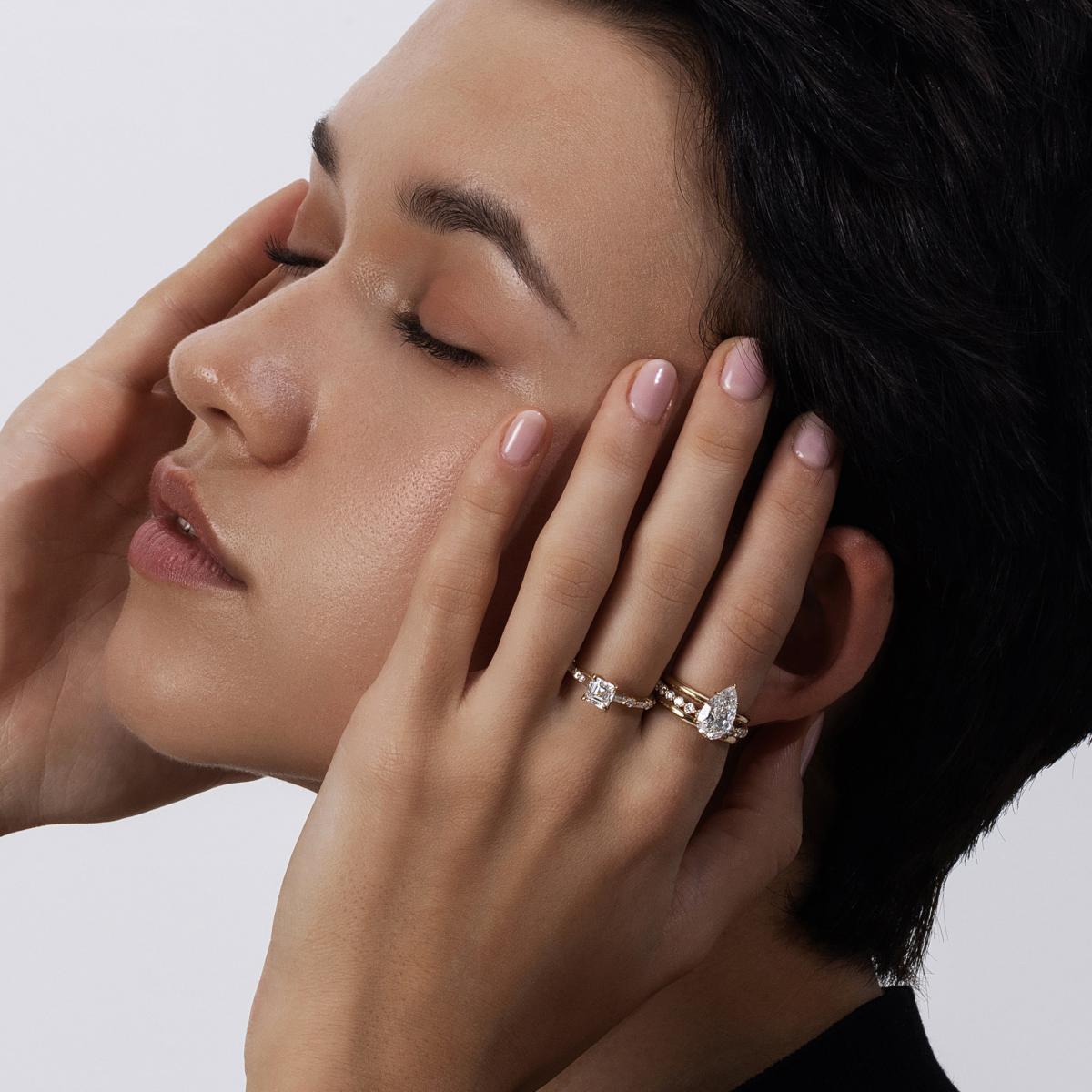 Model wearing Hannah Pear Cut Diamond Ring stacked with a slim pavé band