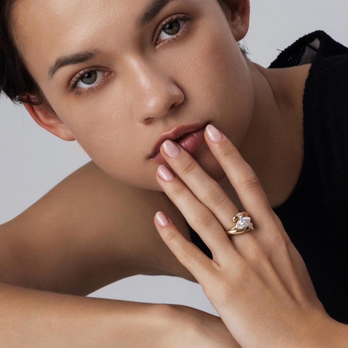 Model wearing Marina Marquise lab-grown diamond East West Engagement Ring stacked with an Embrace Wedding Band