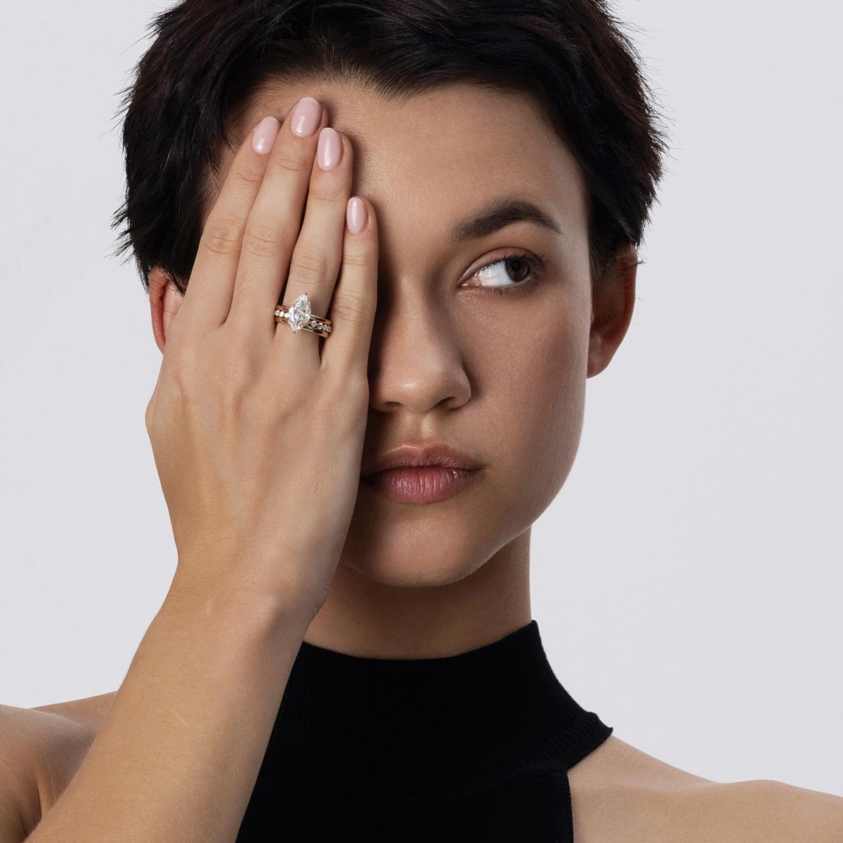 Model wearing Marquise cut Diamond ring stacked with gold eternity and pavé bands