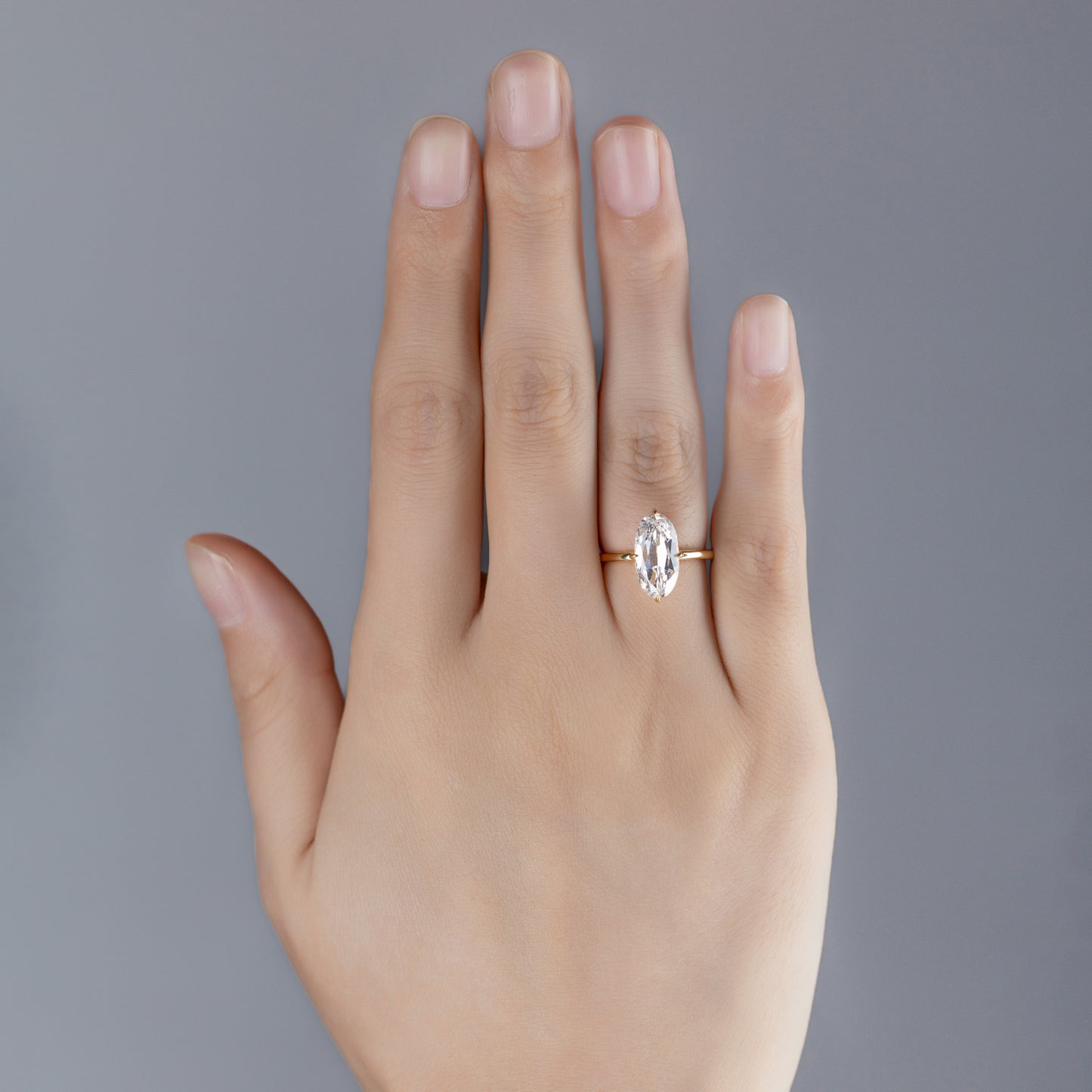 Model wearing Moval cut diamond engagement ring on finger
