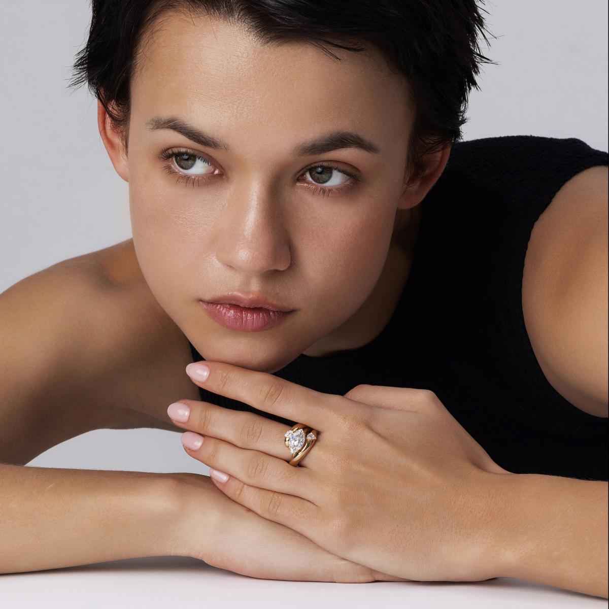 Model wearing a Marquise lab-grown diamond East West Engagement Ring stacked with an Embrace Wedding Band