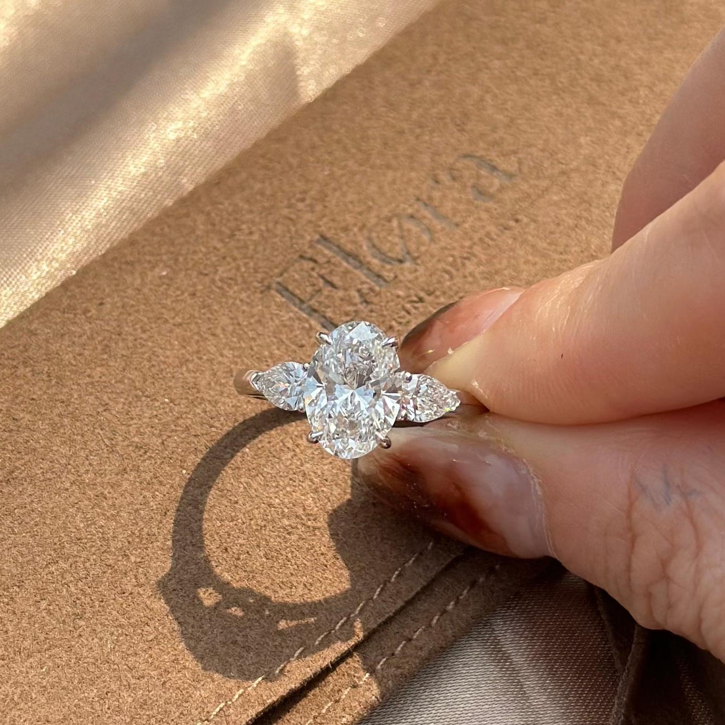 Overhead view of a three-stone Oval cut diamond with 2 pear diamonds