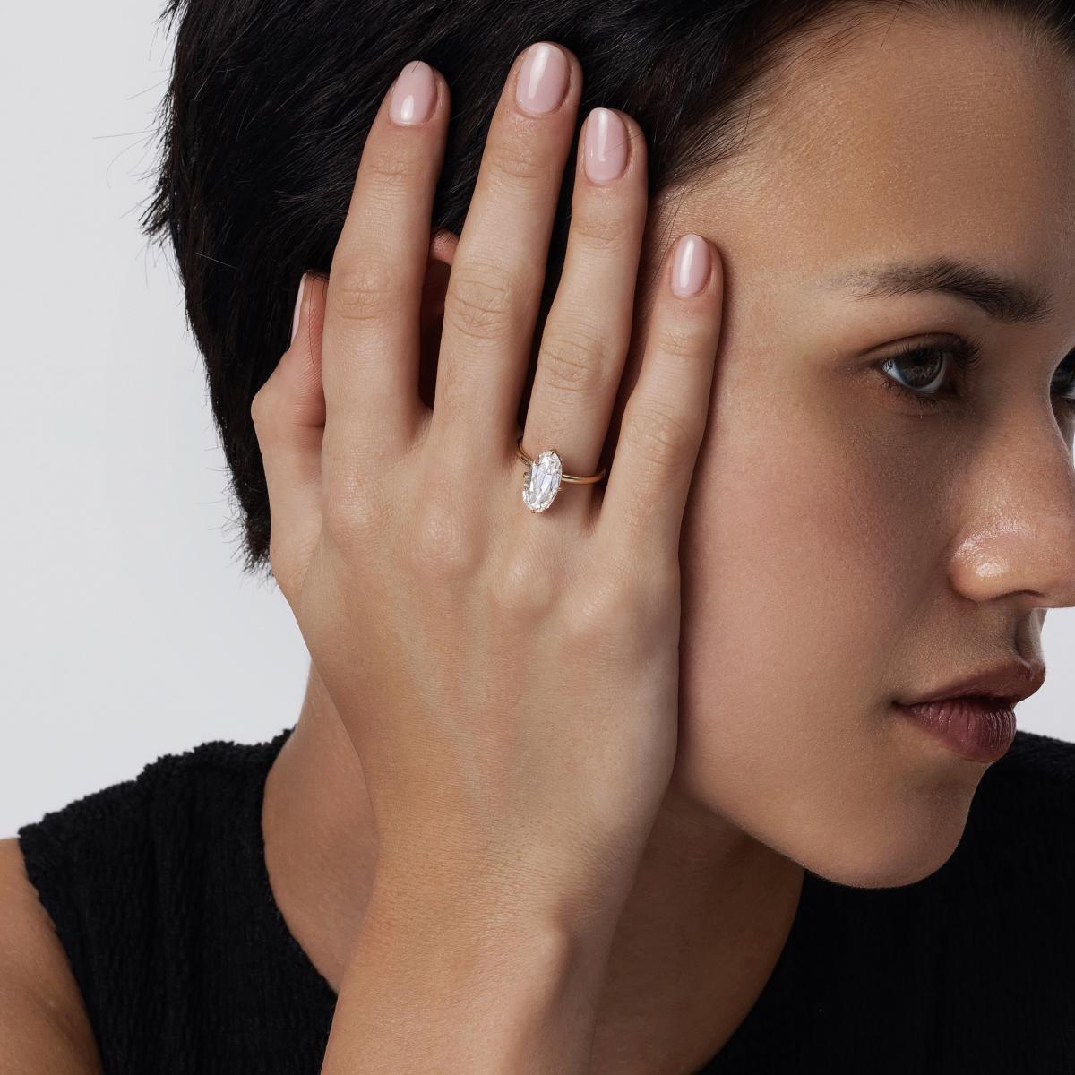 Side angle view of model wearing Moval cut lab-grown diamond engagement ring