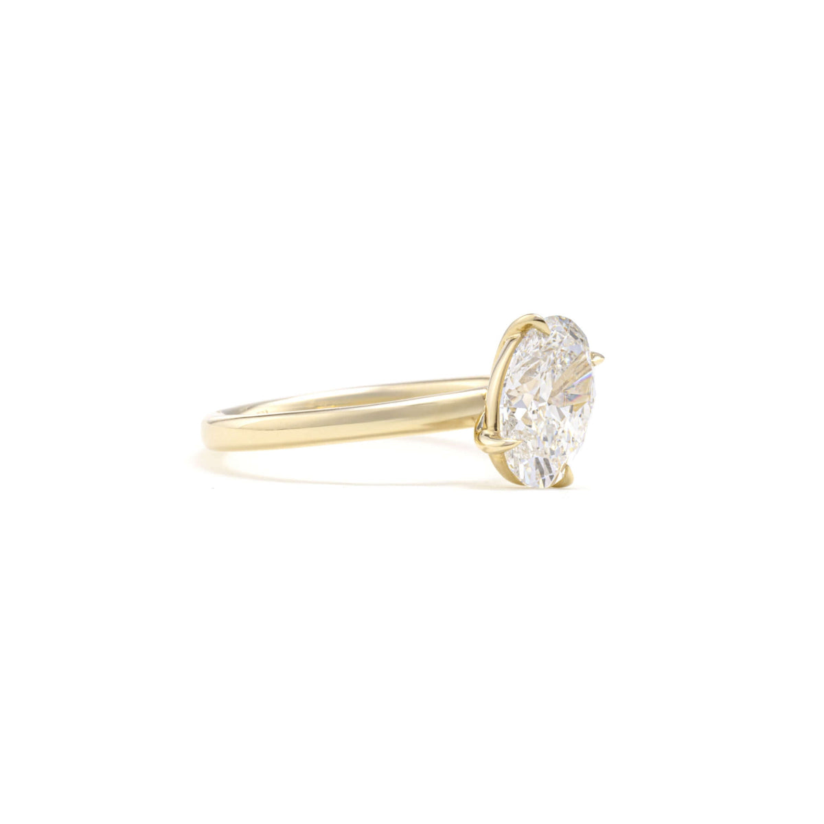 Side profile of Tilted Oval diamond ring with four-prong setting on slim band