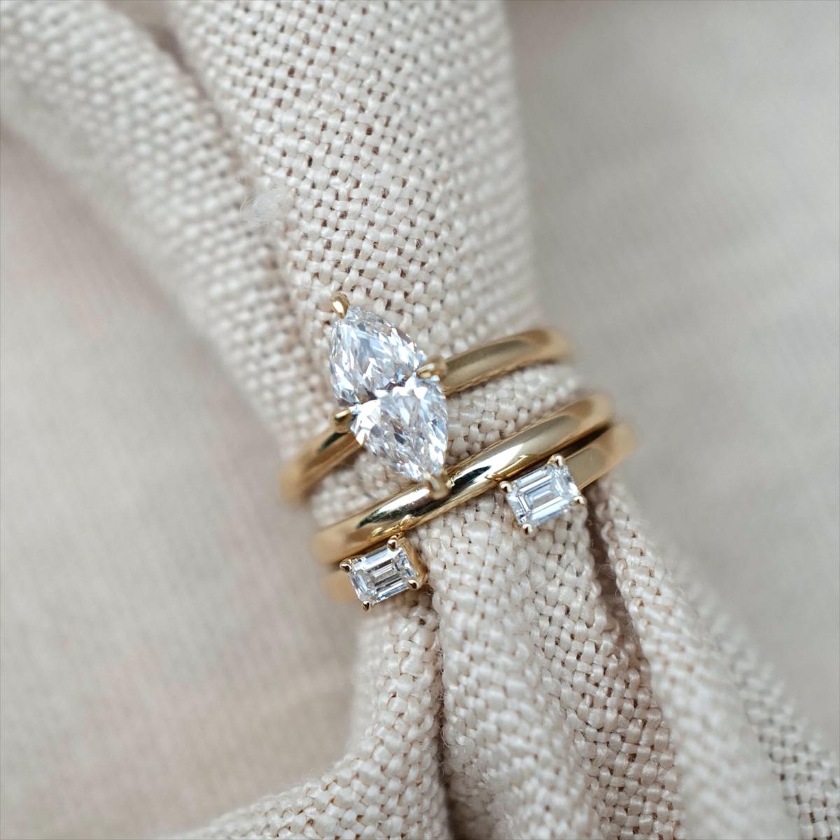 Stacked ring look featuring a solitaire marquise diamond ring and 2 delicate bands in yellow gold