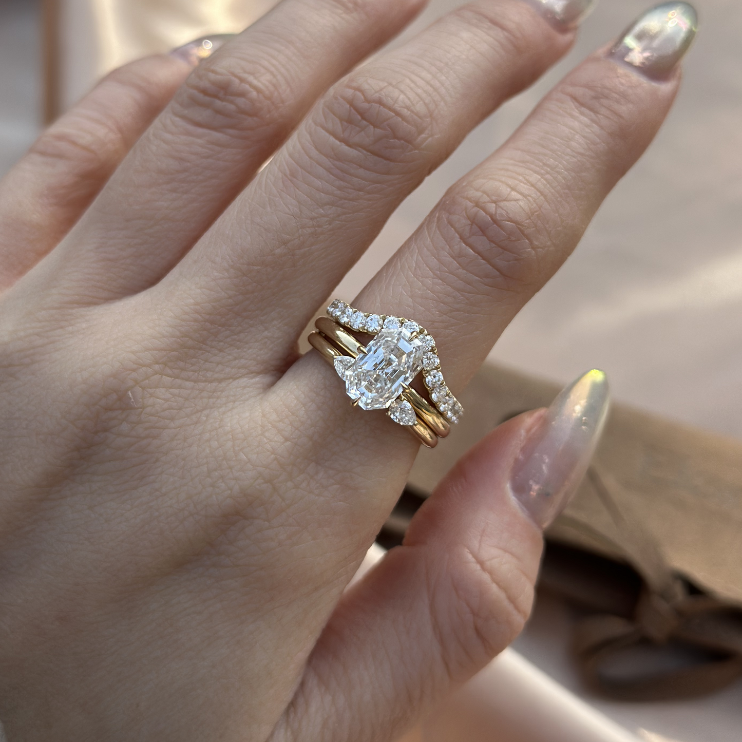 Stacked ring look featuring an Emerald diamond ring and 2 delicate contour band in yellow gold