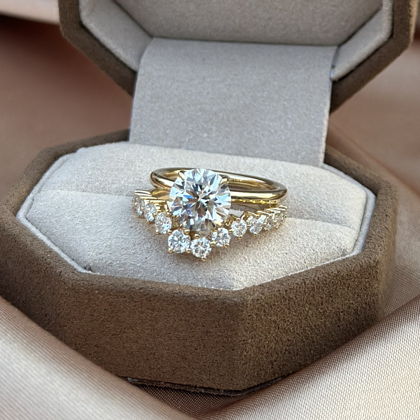 Stacking look featuring a round diamond ring and a delicate curved wedding band in box