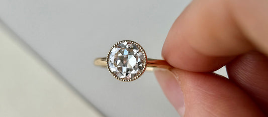 Milgrain in jewelry enhances ring design, showcasing a diamond ring with bead-like edges around the stone.