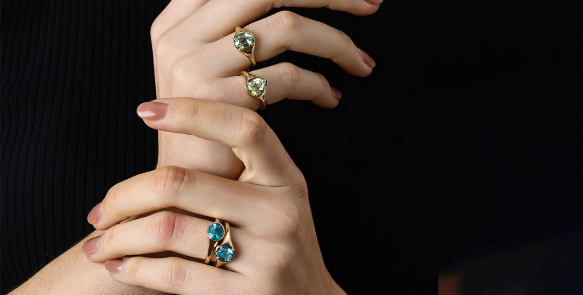 Gemstone Tourmaline rings featured on elegant hands showcasing vibrant colors and unique designs.