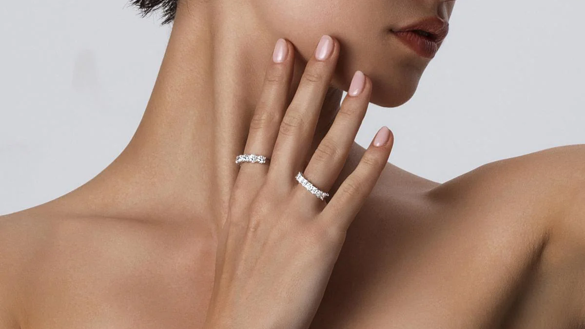White Gold Wedding Band worn on two fingers showcasing elegant diamond accents and a polished finish.