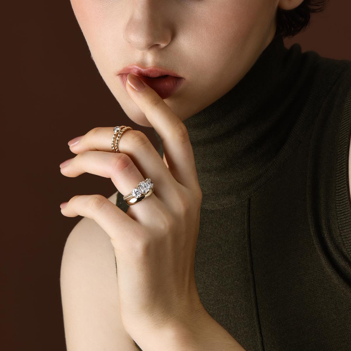 The Marcella Antique Cut Lab Grown Diamond Three Stone Engagement Ring with matching curved band worn on hand