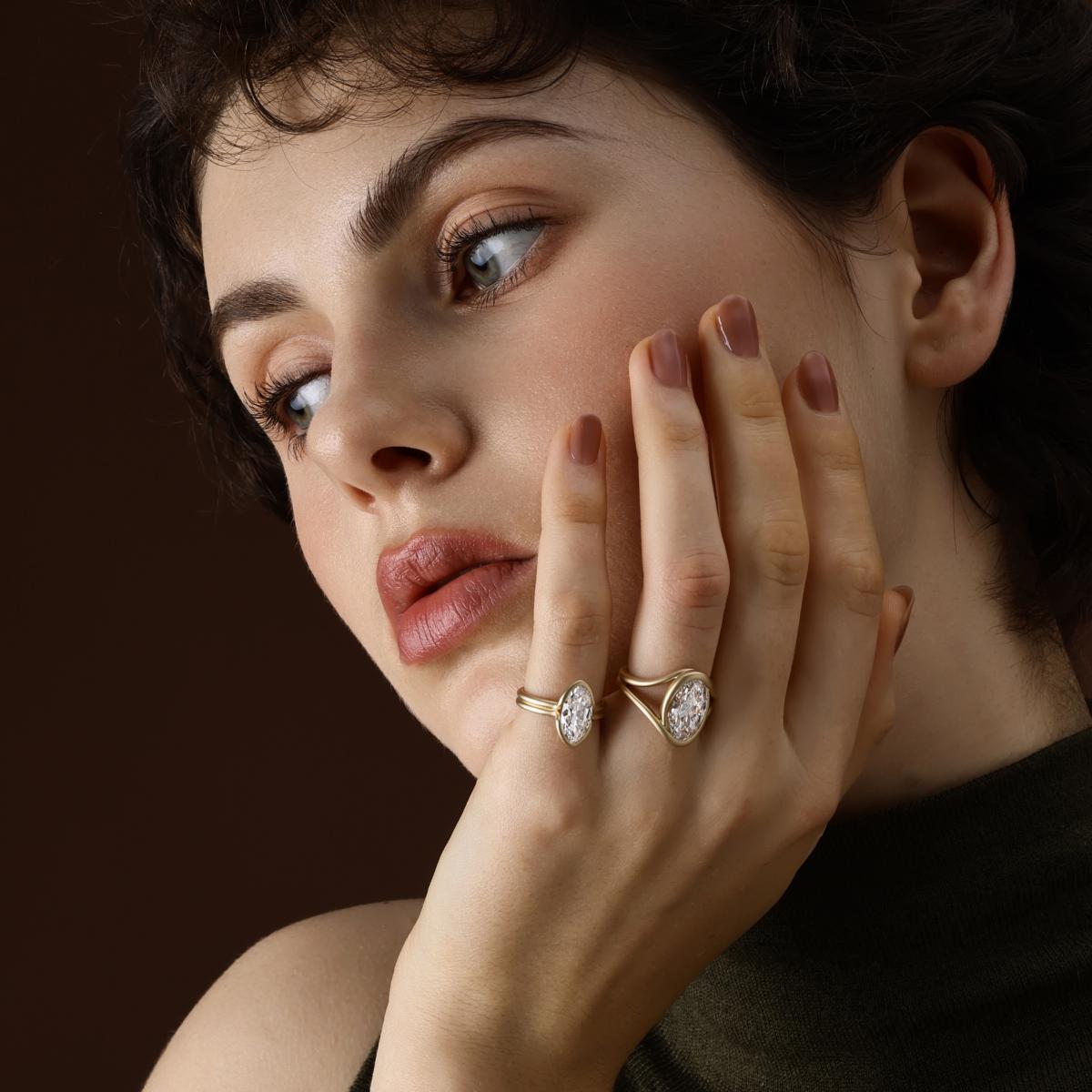 Model wearing moval cut lab grown diamond engagement ring in a stacked ring look