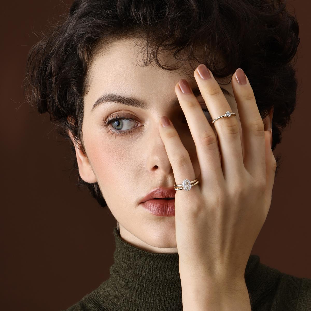 Model Wearing the Alma Bezel Round Cut Lab Grown Diamond in 14K/18K Yellow Gold Twist Band on middle finger