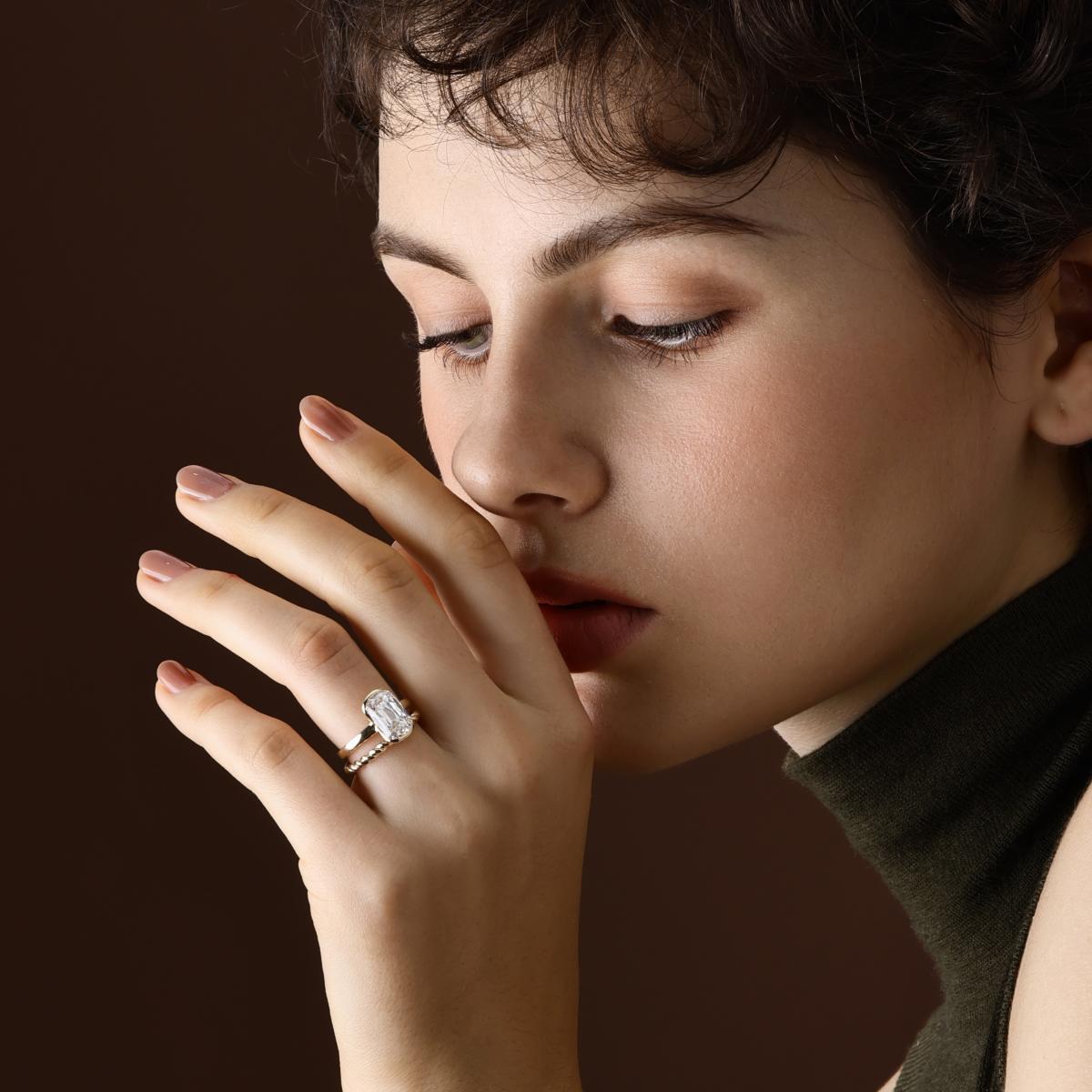 Model wearing an old mine cut lab grown diamond engagement ring with a twist Yellow Gold Wedding Band