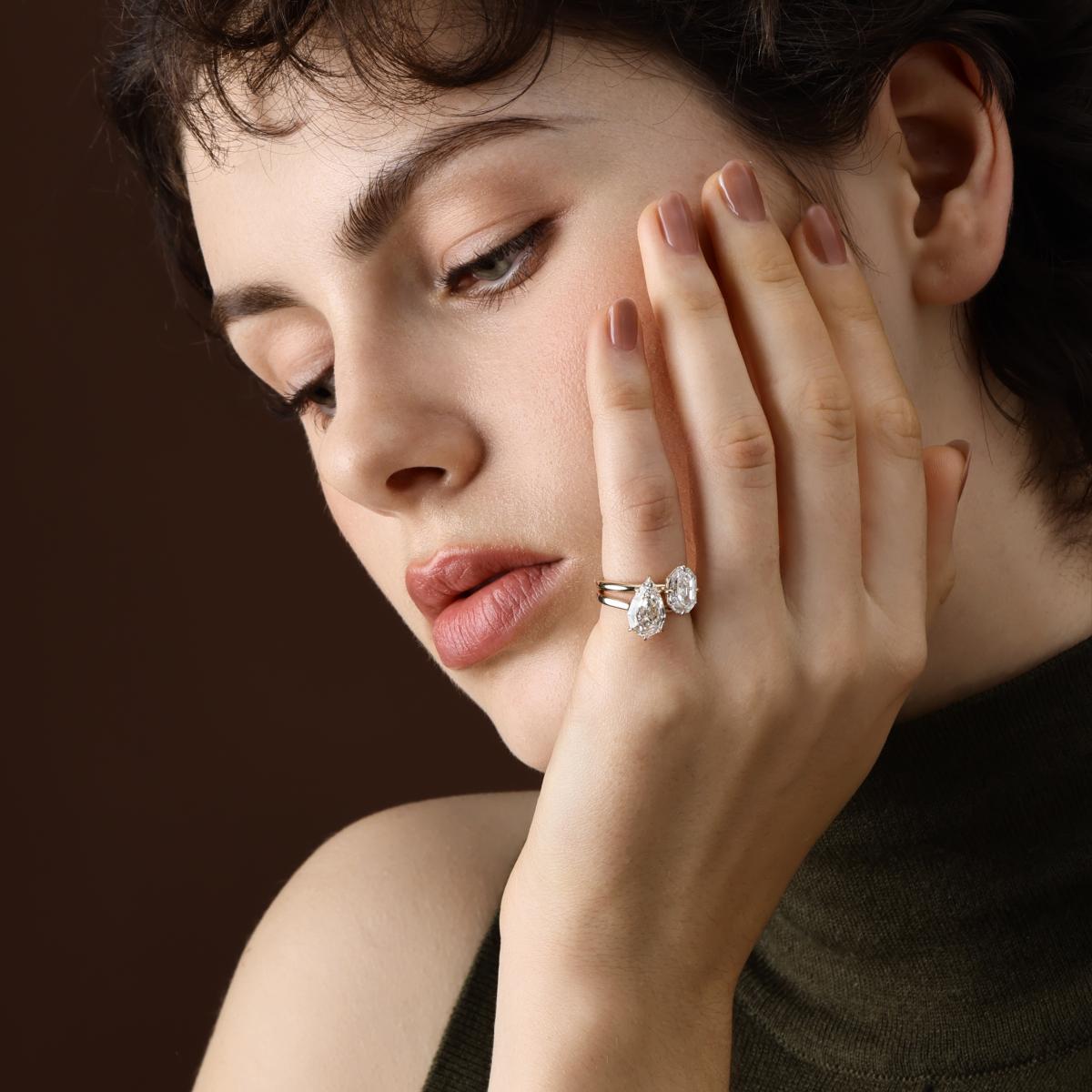 Step cut pear lab grown diamond engagement ring shown on hand in a stacked styling