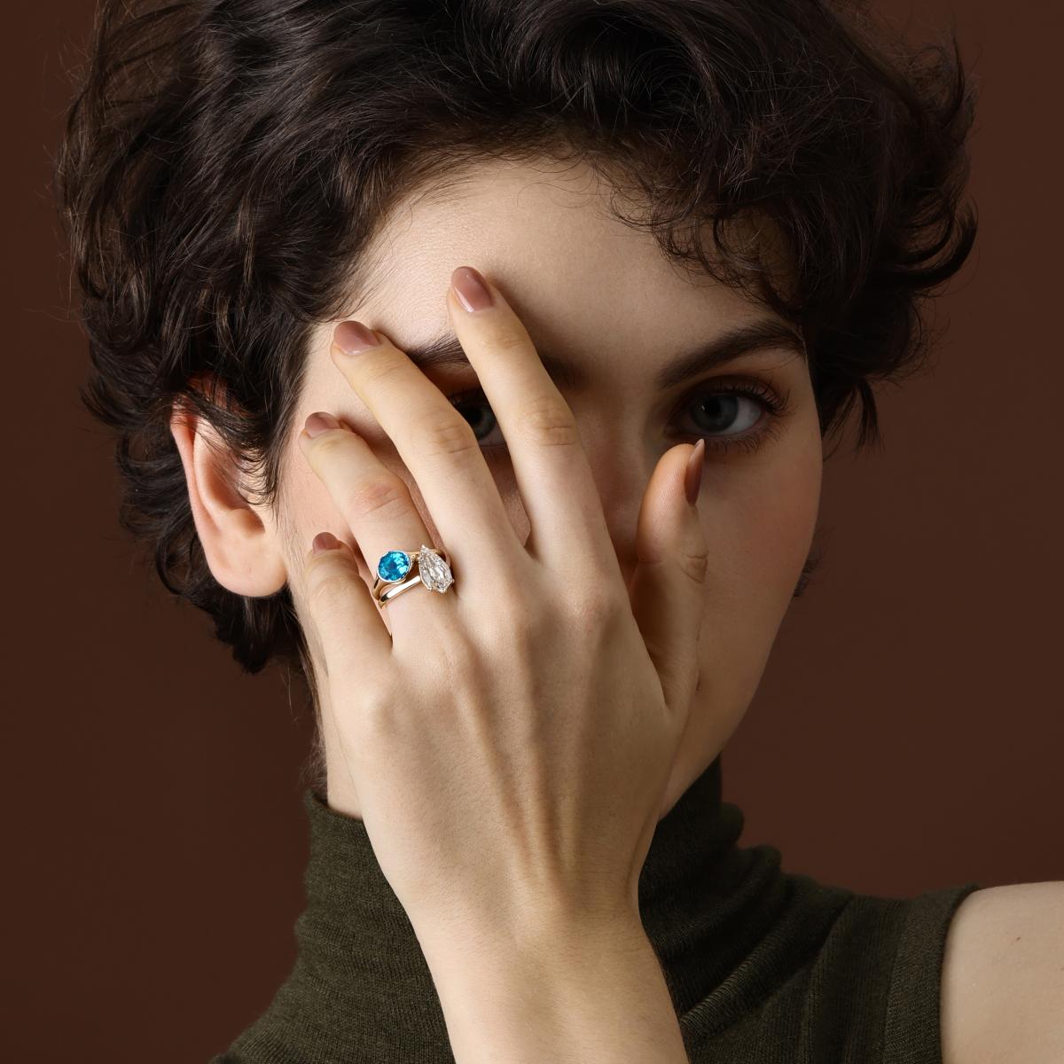 Model wearing step cut pear lab grown diamond engagement ring styled with an oval Paraiba gemstone ring