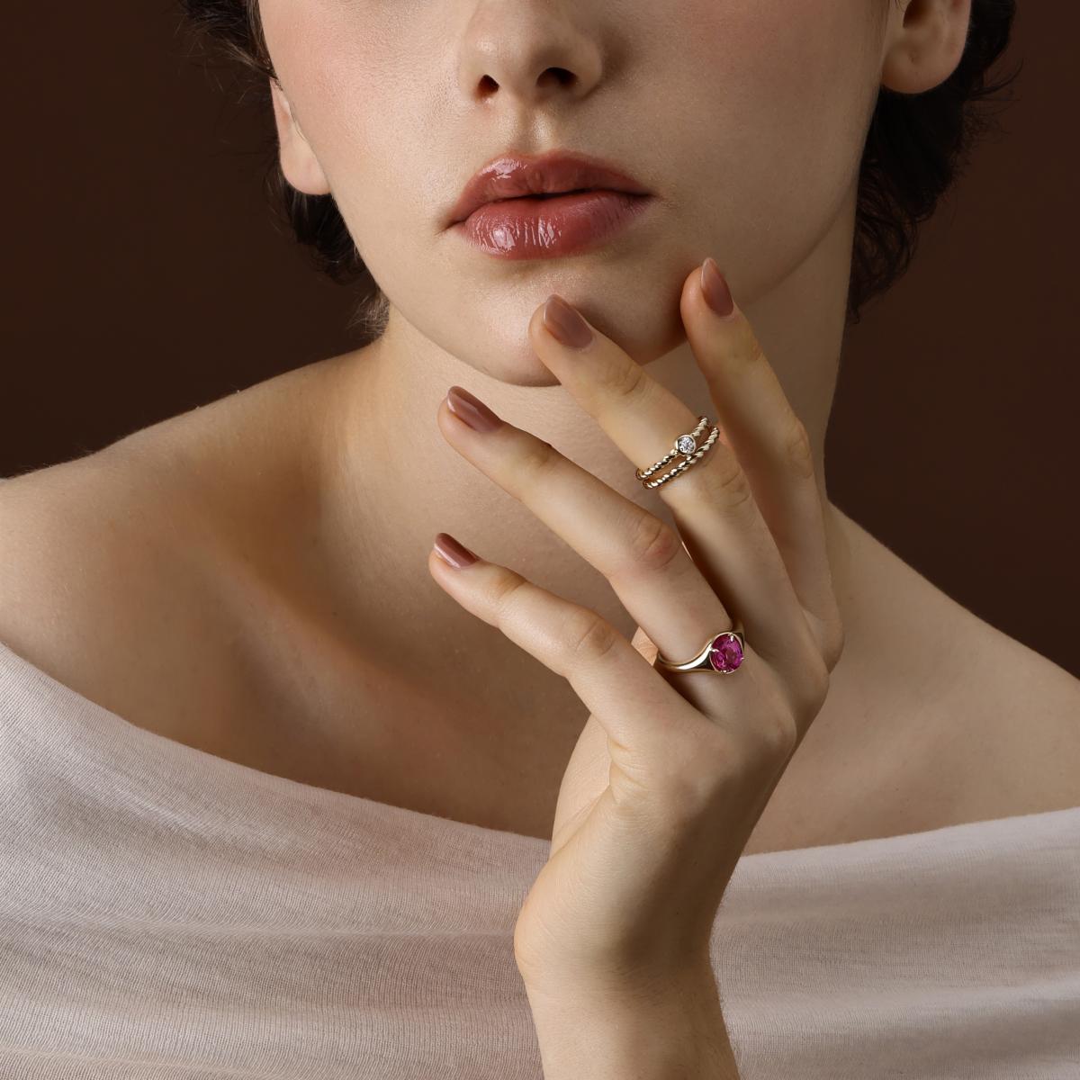 Model Wearing the Evie Oval Cut Lab Grown Pink Sapphire Ring styled with other bands