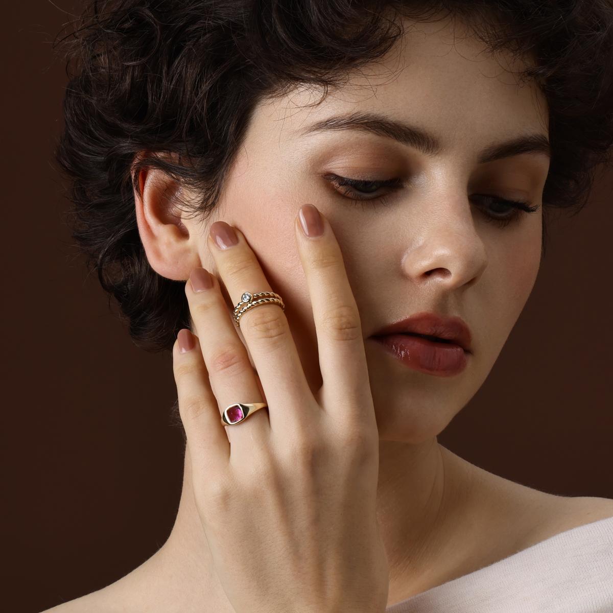 Model wearing the Sarah Sugarloaf Cabochon Pink Tourmaline Ring styled with gold bands