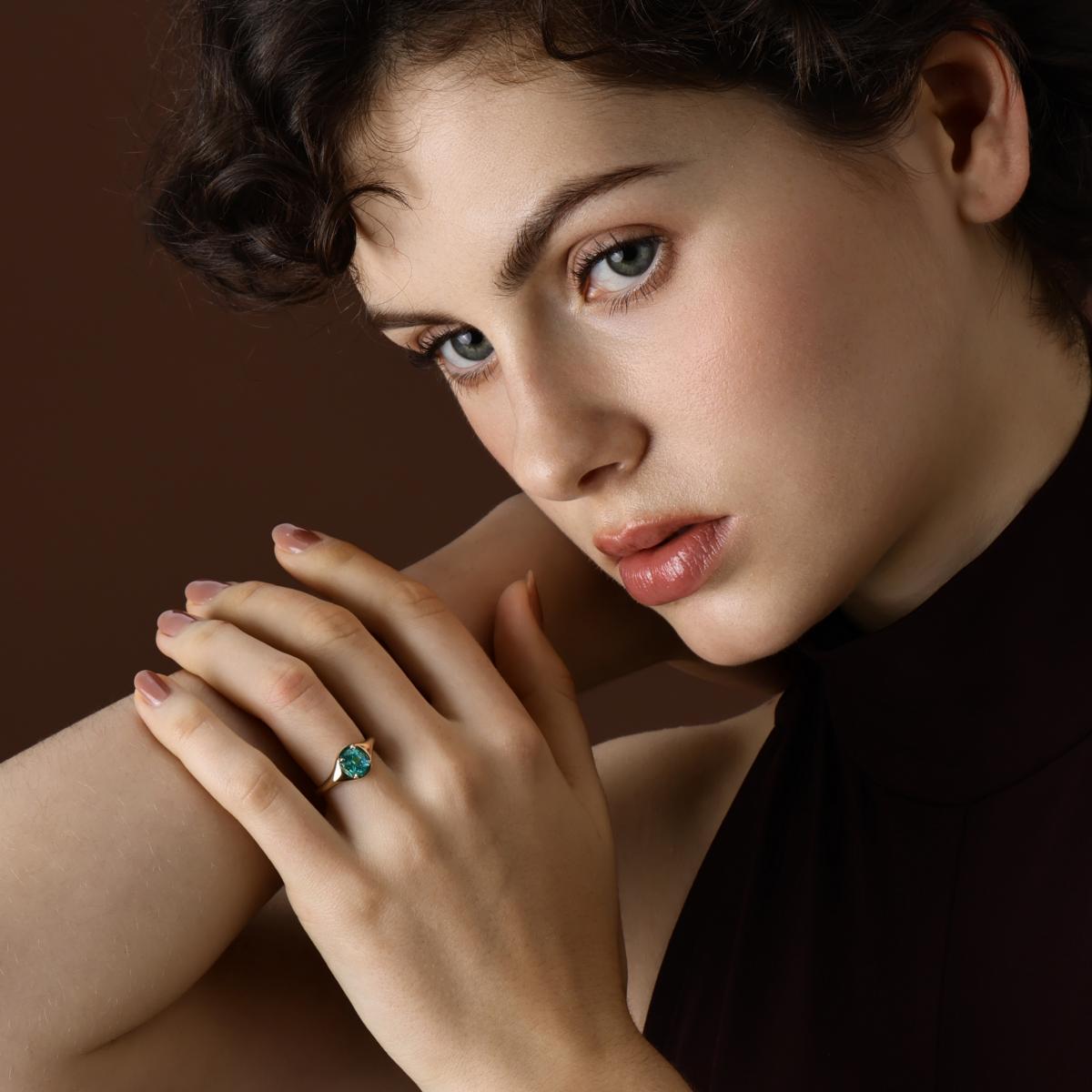 Model wearing the Evie Oval Cut Lab Grown Paraiba Ring in 14k yellow gold