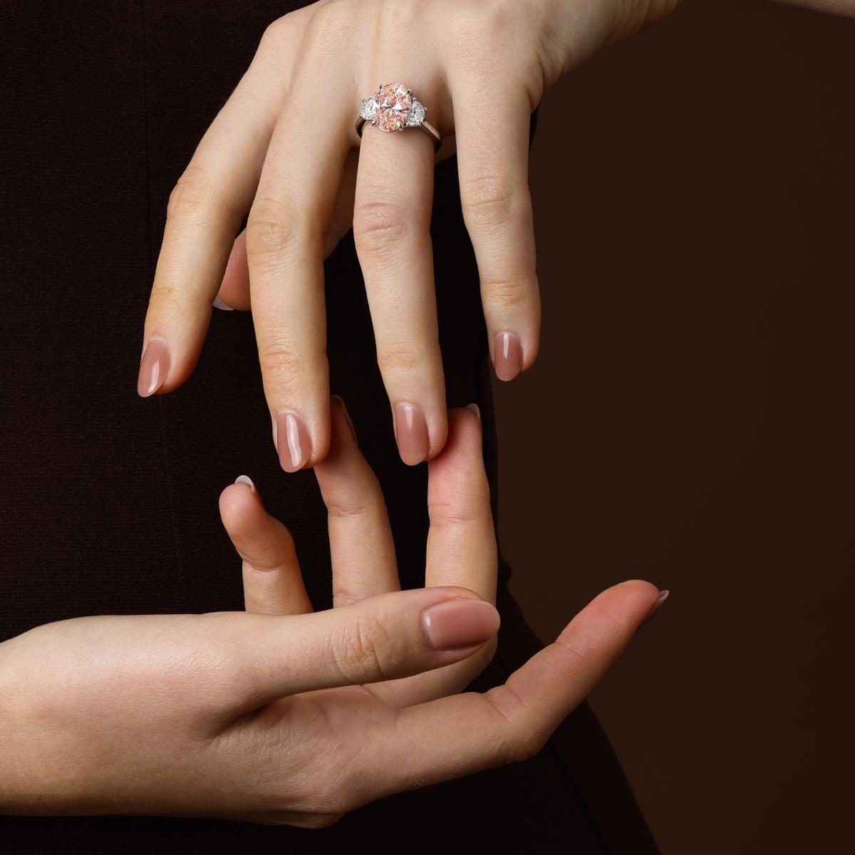 The Phoebe Pink oval cut lab grown diamond engagement ring shown on hand