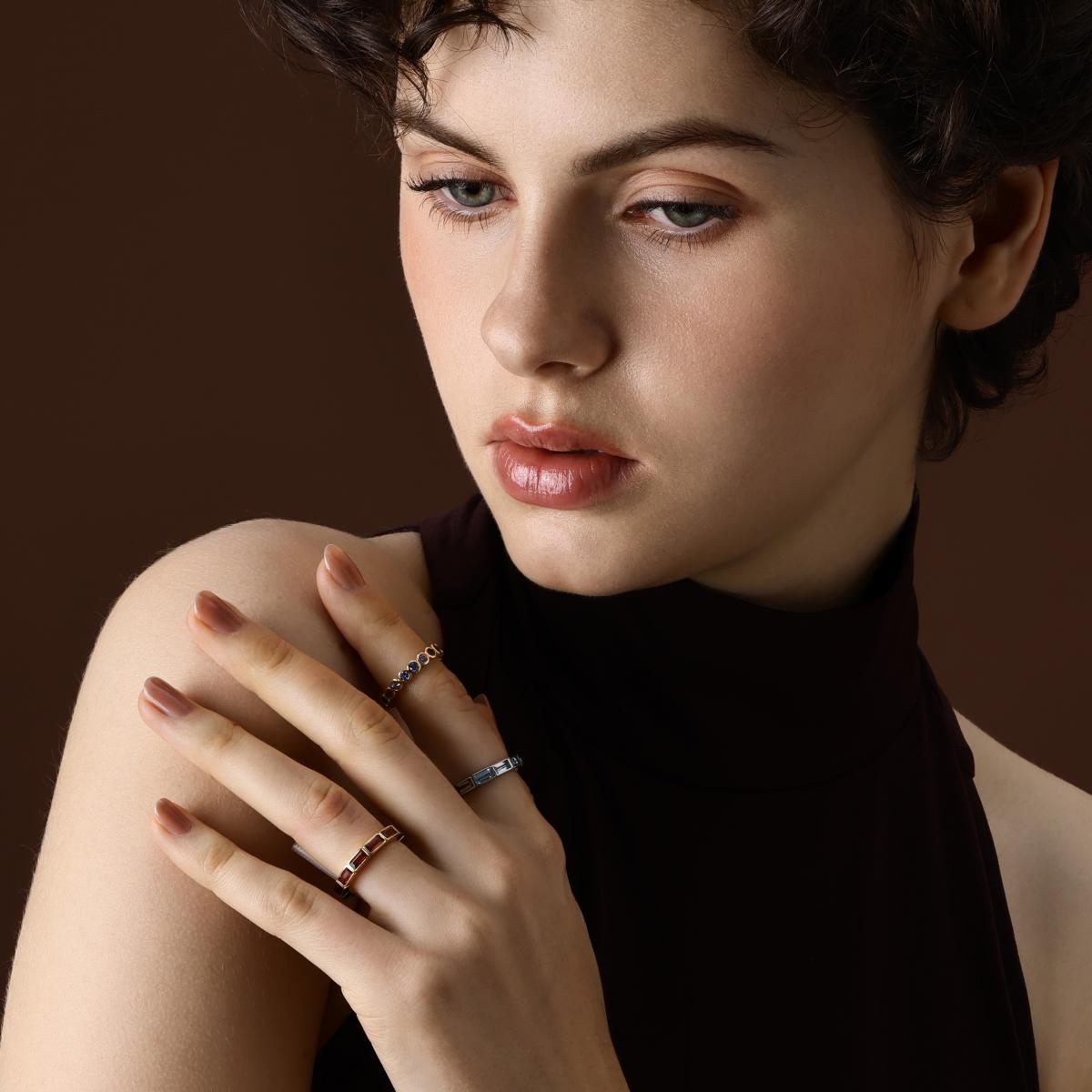 Round cut lab grown blue sapphire eternity band styled with other eternity bands