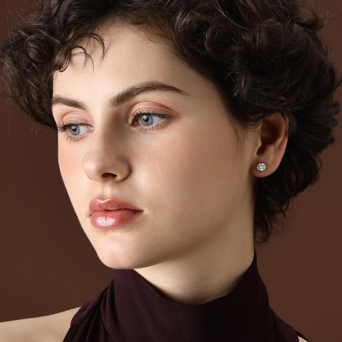 Model wearing Classic Bezel Round Diamond Stud Earrings in Platinum