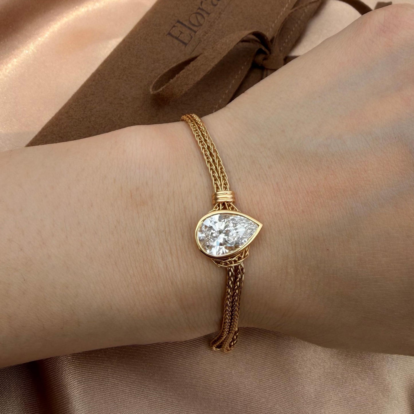 Faith-Pear Cut Lab Grown Diamond Bracelet featuring a pear-cut diamond and 18K gold chain on a wrist.