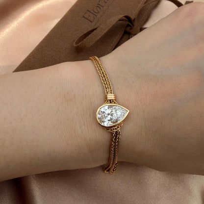 Faith-Pear Cut Lab Grown Diamond Bracelet featuring a pear-cut diamond and 18K gold chain on a wrist.