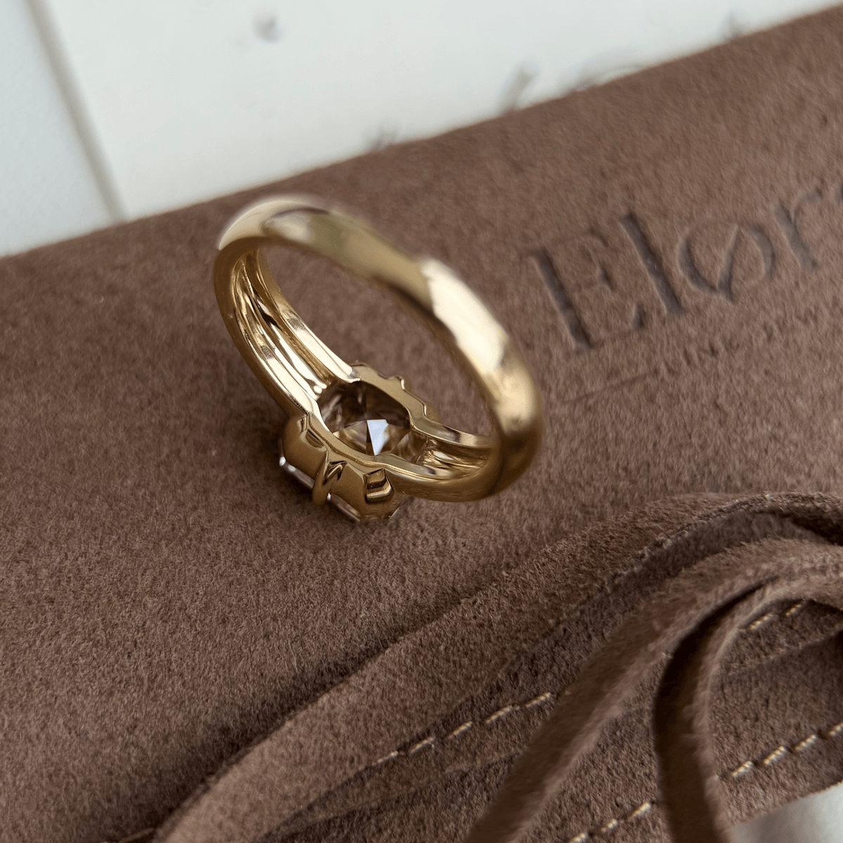 Sintra-Champagne Asscher Cut Lab Grown Diamond Ring displayed on a soft brown surface with elegant detailing.