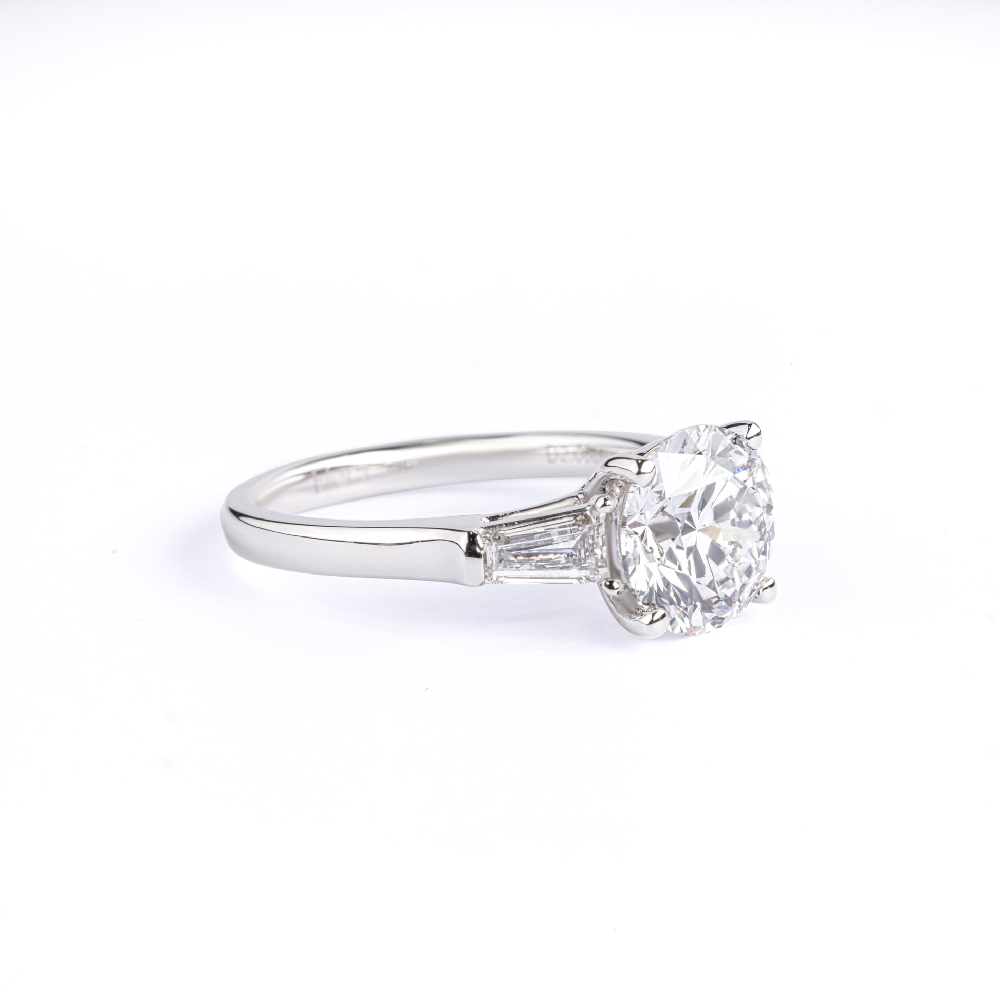 Angled View Three-Stone Round Diamond Engagement Ring with two tapered baguette diamonds
