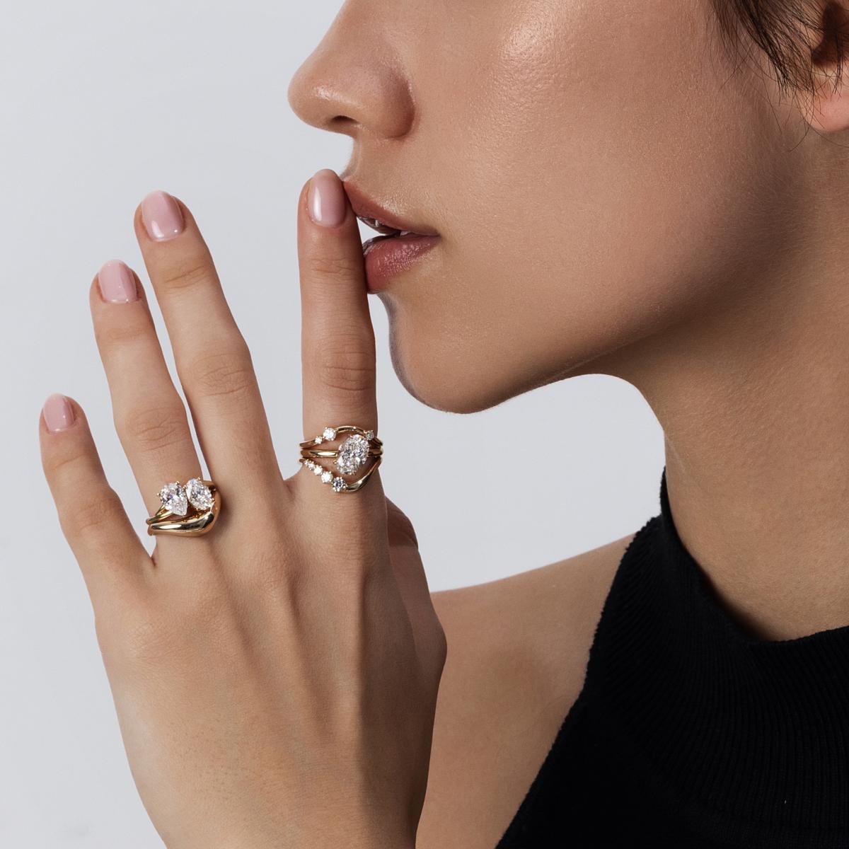 Clara contour ring stacked with solitaire engagement ring, forming a perfect arc
