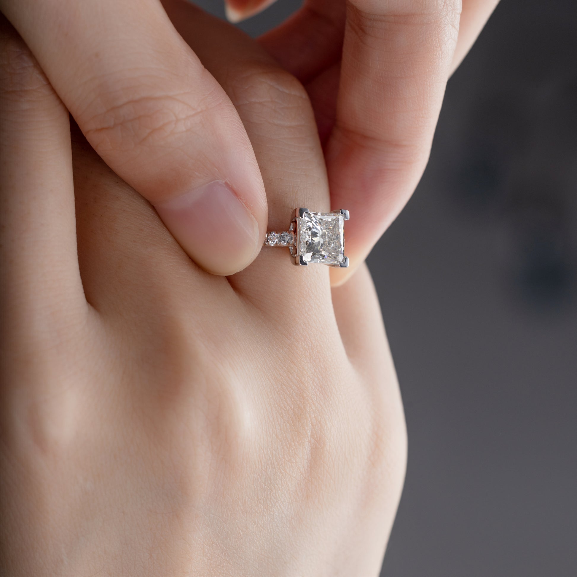 Close-up of Princess cut Lab Grown diamond pavé setting Engagement Ring on model’s finger