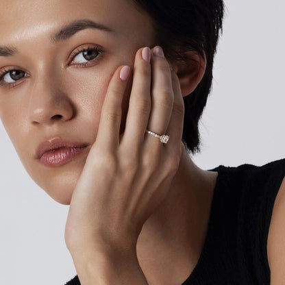 Close-up of model wearing Asscher cut diamond ring with tapered round and baguette diamonds