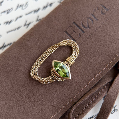 Faith-Marquise Cut Natural Peridot Gemstone Chain Ring atop a stylish Elora jewelry case, showcasing its elegant design.