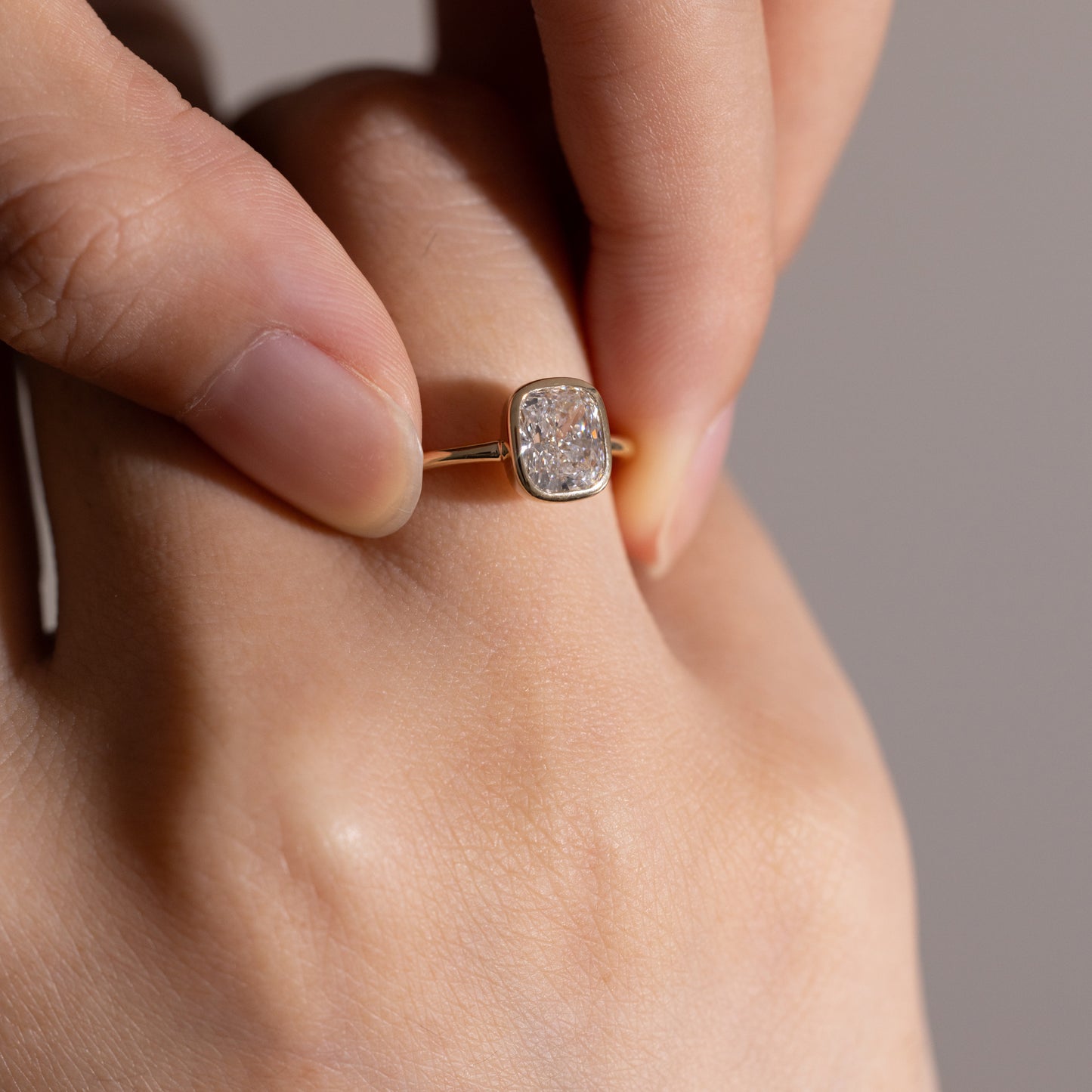 Hand closeup of Hazel-Cushion Cut Lab Grown Diamond Bezel Ring