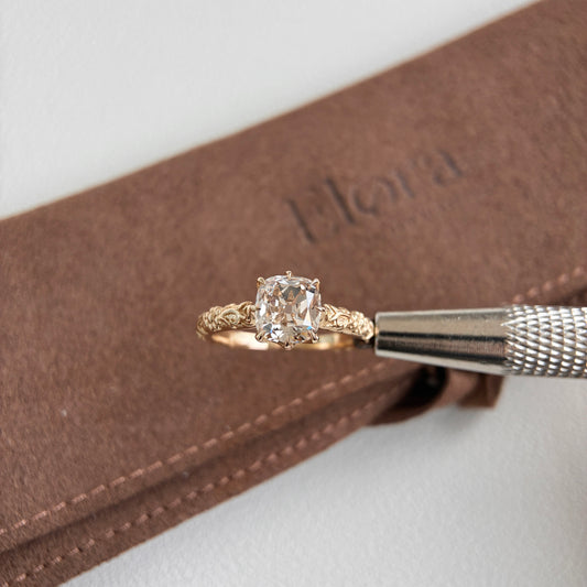 Alba-1.46ct Champagne Old Mine Cushion Lab Grown Diamond Ring displayed on a brown jewelry pouch.