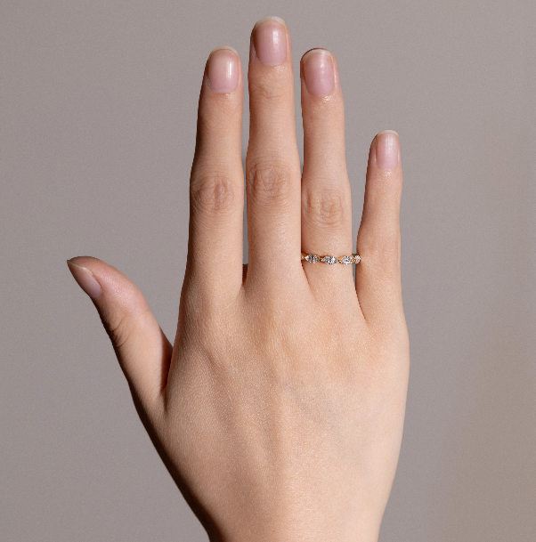 Maeve eternity wedding band worn alone on finger, glowing with delicate sparkle