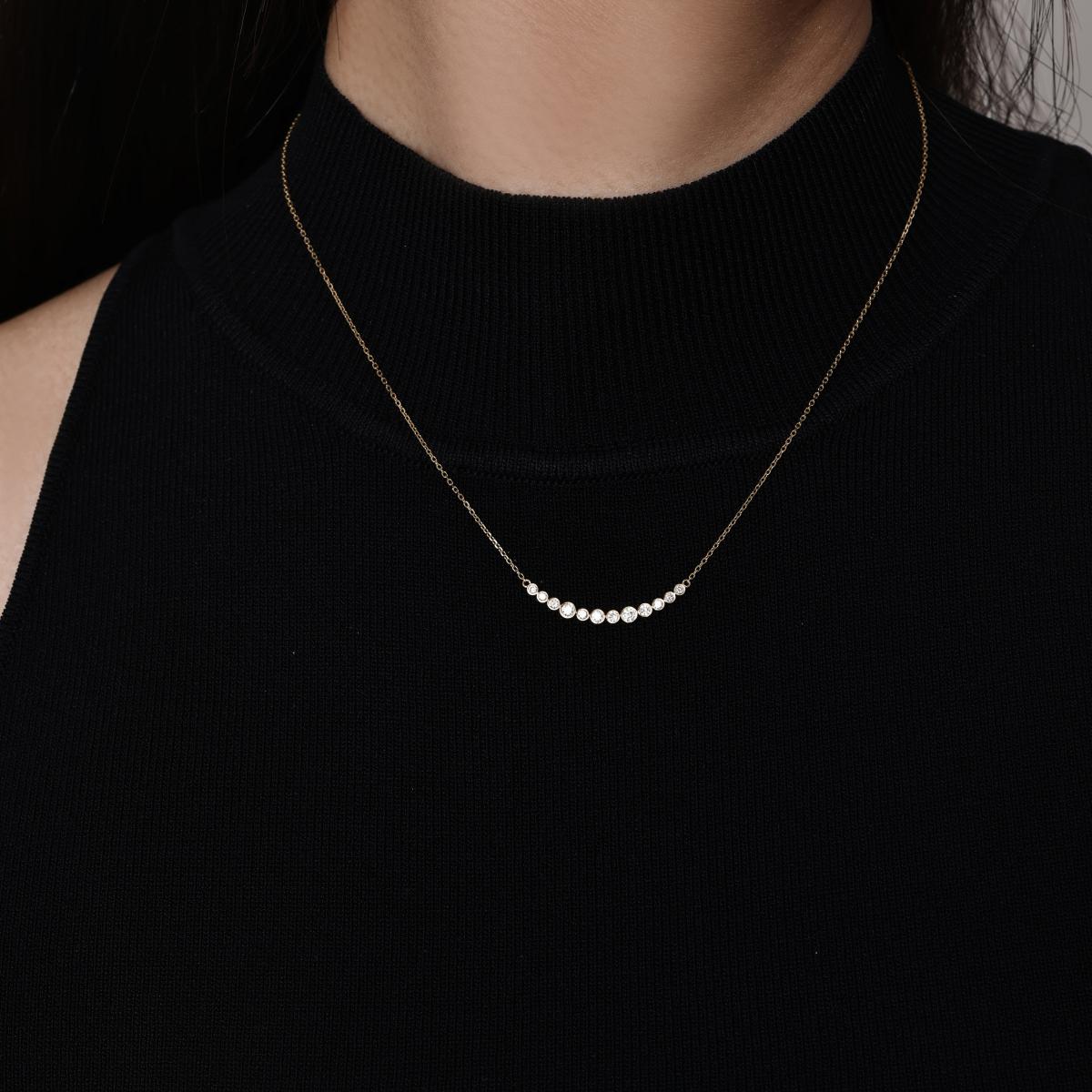 Model wearing a curve of bezel-set Graduated round diamonds Necklace 16–18" Chain Length (adjustable)
