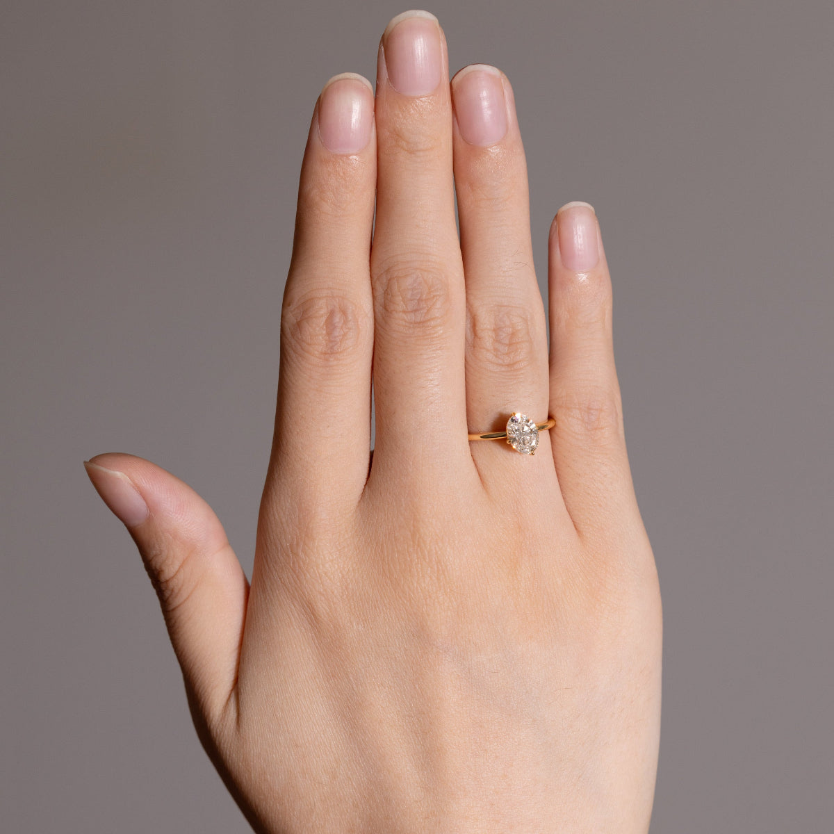 Model wearing a diamond engagement ring on finger, minimalist and radiant look