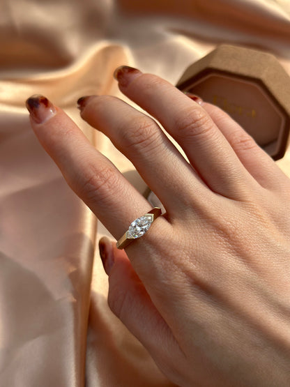 Overhead view of model’s hand wearing a Marquise Cut Lab Grown Diamond East West Ring in yellow gold
