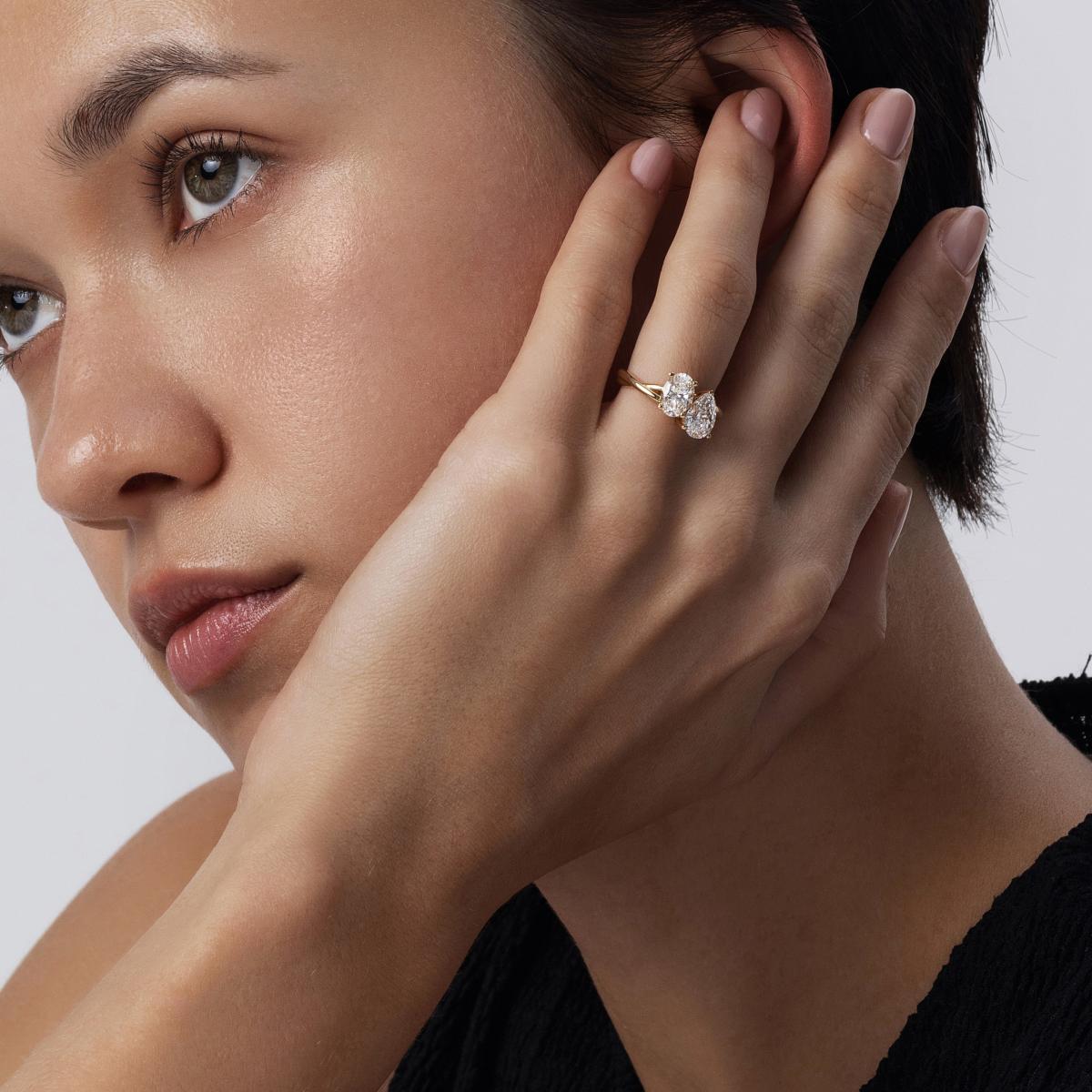 Side hand view of model wearing Ivy Pear and Oval Cut Diamond Toi et Moi Ring
