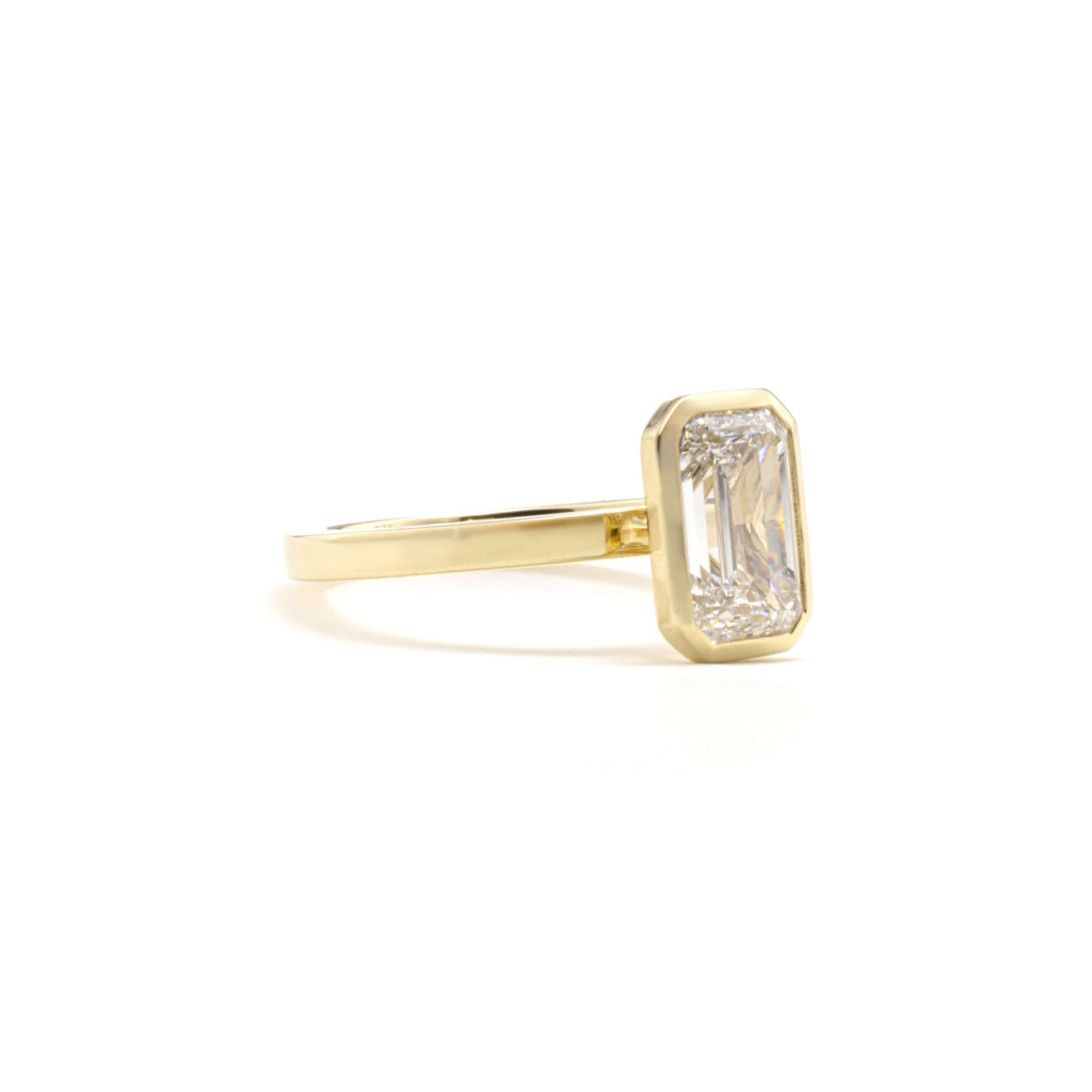 Side profile of Aurora Ring showcasing emerald-cut diamond in bezel setting